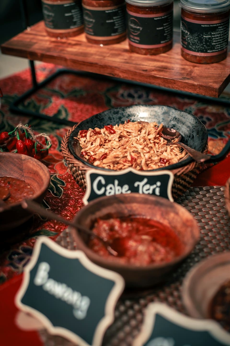 Various Southeast Asian food products displayed on a patterned textile.